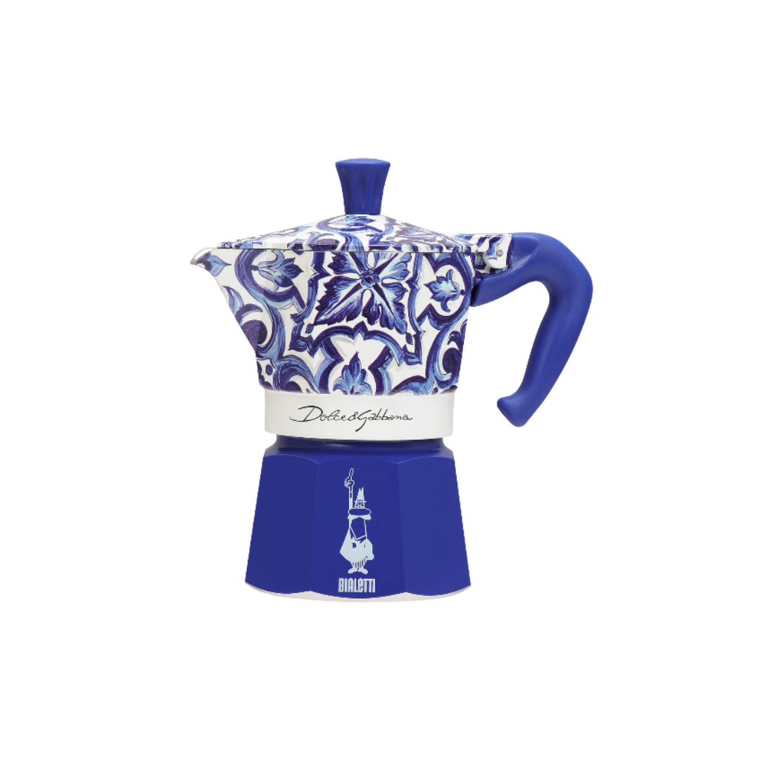Bialetti coffee maker beside Dolce&Gabbana luxury accessories, epitomizing elegance and sophistication