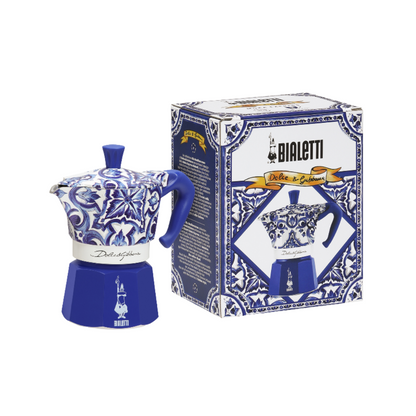Bialetti coffee maker beside Dolce&Gabbana luxury accessories, epitomizing elegance and sophistication