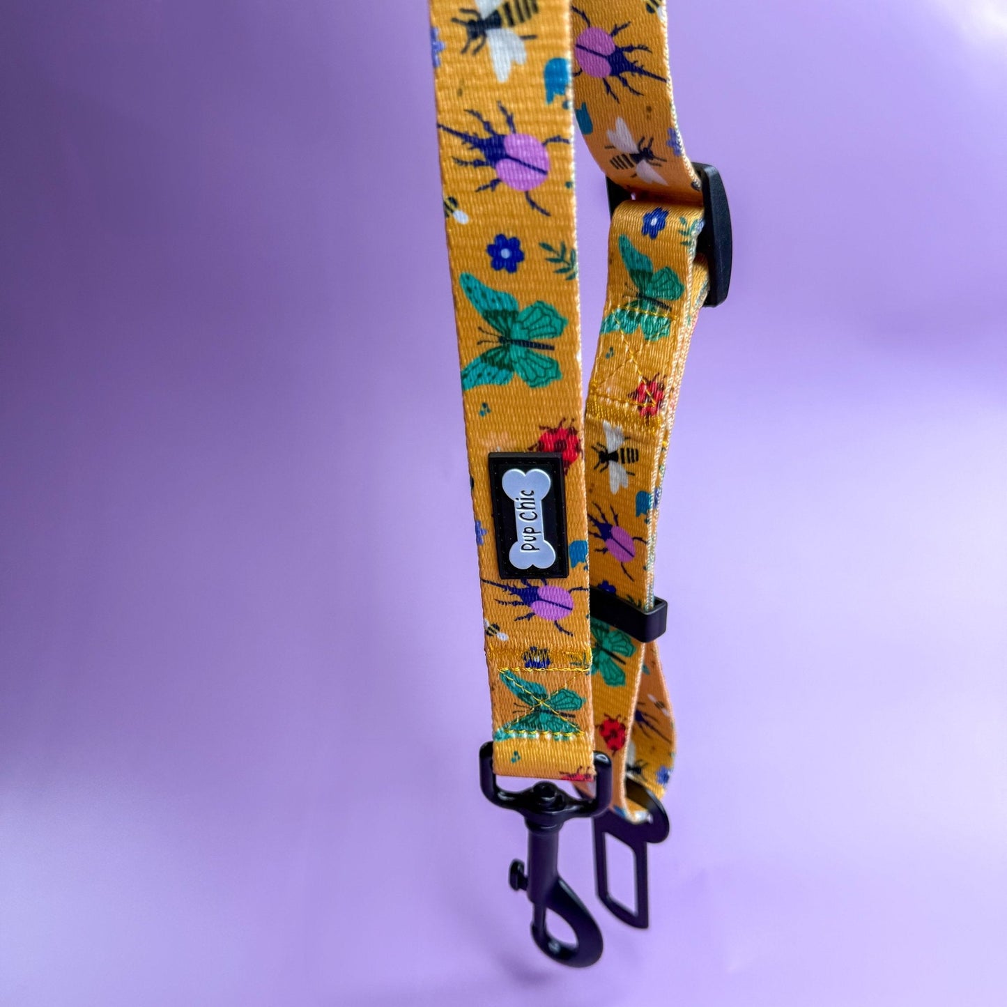 Summer Buzzin’ adjustable dog seat belt clip in mustard yellow with insect print