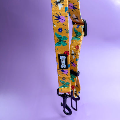 Summer Buzzin’ adjustable dog seat belt clip in mustard yellow with insect print