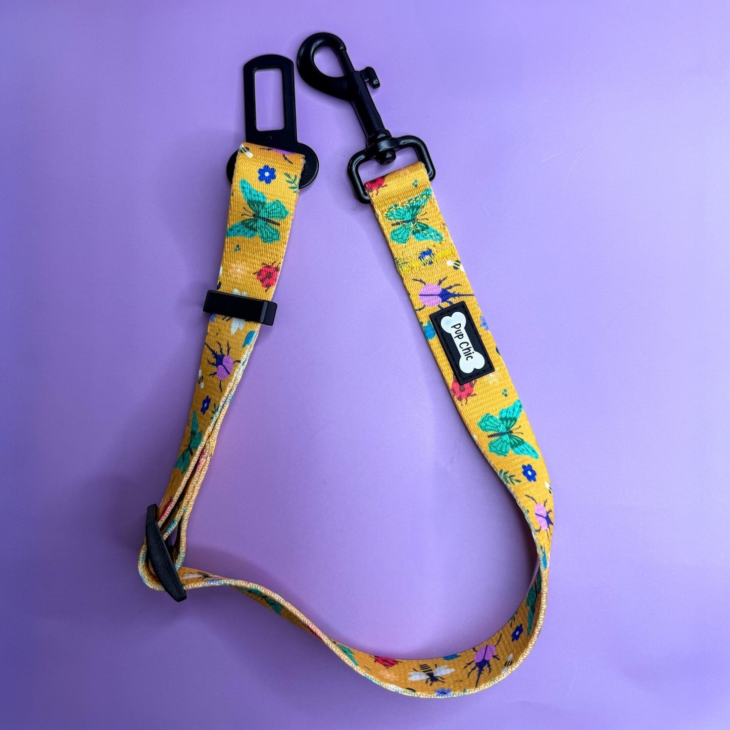 Summer Buzzin’ adjustable dog seat belt clip in mustard yellow with insect print