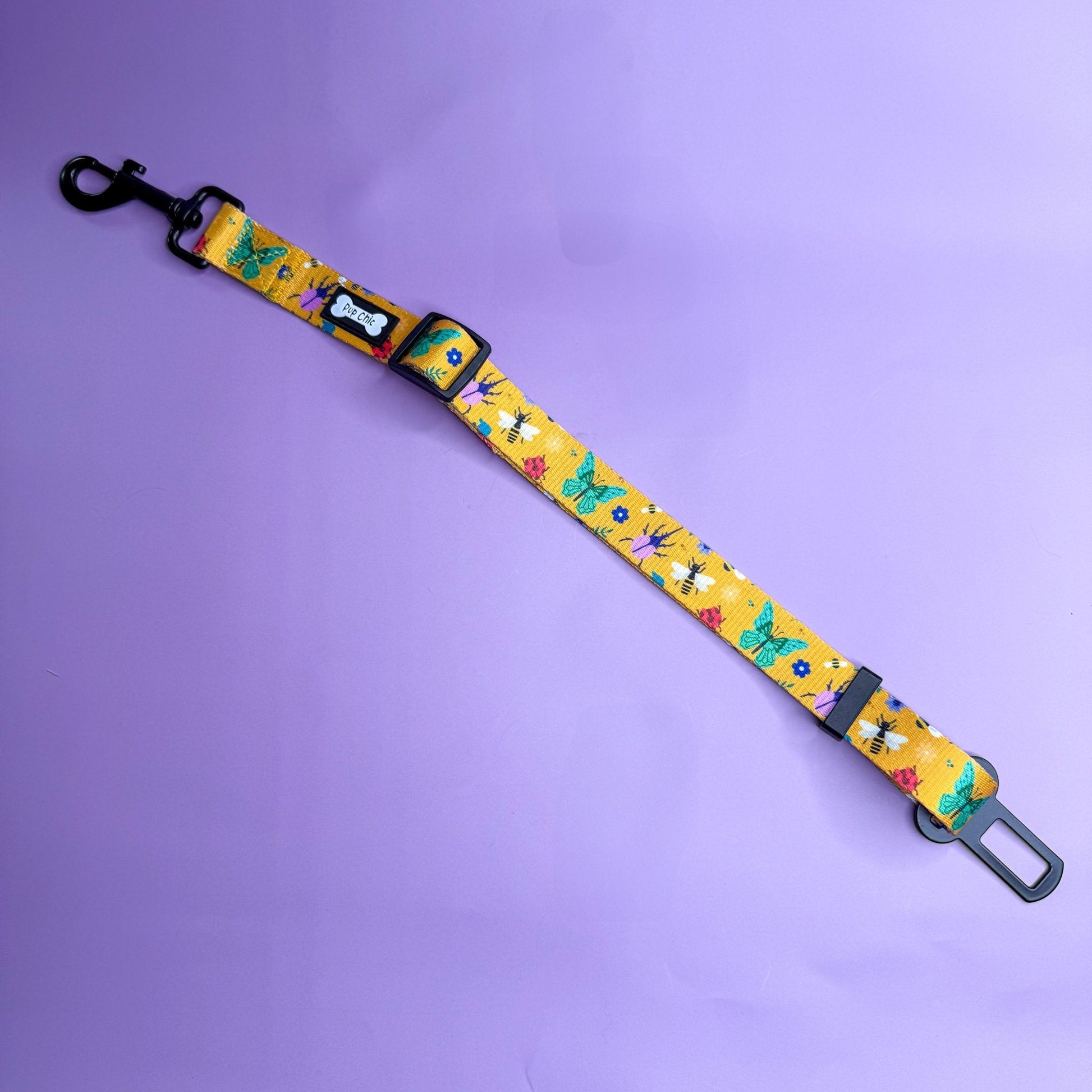 Summer Buzzin’ adjustable dog seat belt clip in mustard yellow with insect print