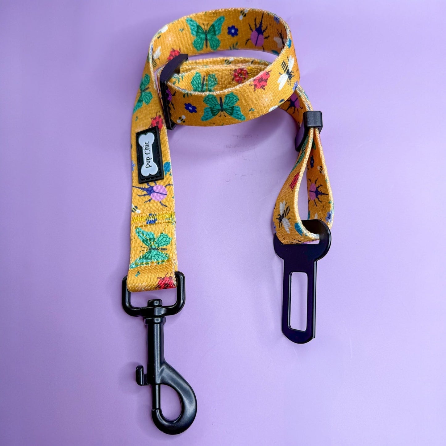 Summer Buzzin’ adjustable dog seat belt clip in mustard yellow with insect print